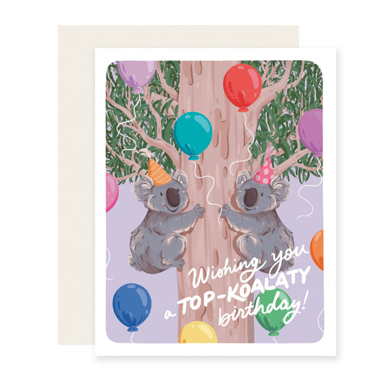 Vibrant birthday card featuring two koalas in a tree wearing party hats, with colorful balloons. The card reads 'Wishing you a top koalaty birthday.'