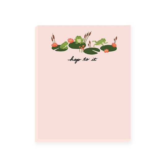 A light pink notepad featuring adorable frog and lily pad illustrations at the top. The notepad's header humorously reads 'Hop to it.' This playful notepad is perfect for adding a touch of whimsy to your notes and tasks.