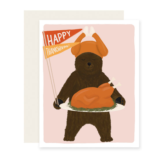 A Thanksgiving card with an adorable bear wearing a turkey hat, holding a turkey platter, and waving flags that say 'Happy Thanksgiving.' 